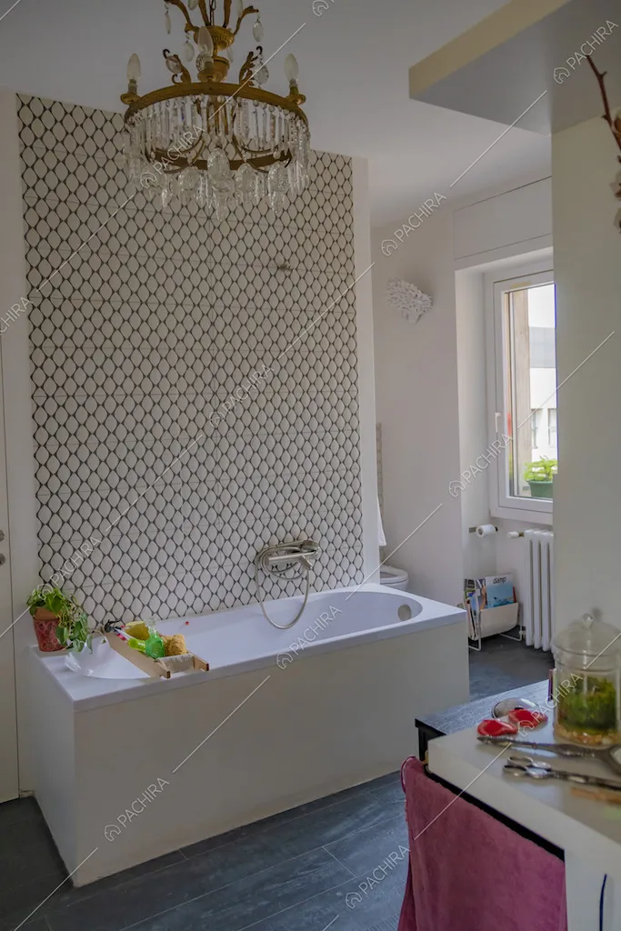 Bagno con vasca e lampadario antico