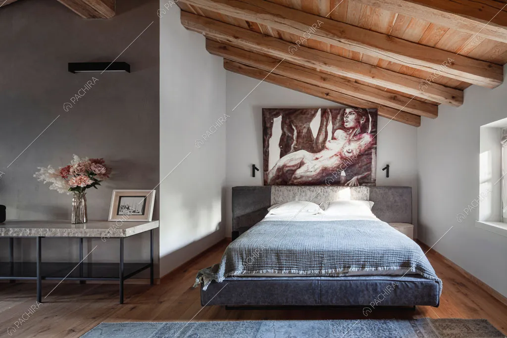 Camera da letto con travi a vista sul soffitto nella villa Ghibli, location in stile contemporaneo a Verona