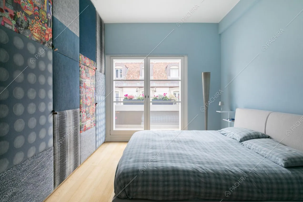 Letto matrimoniale con pavimento in parquet e pareti azzurre