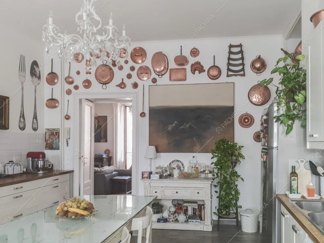 Pentole in rame di varie dimensioni appese alla parete in cucina