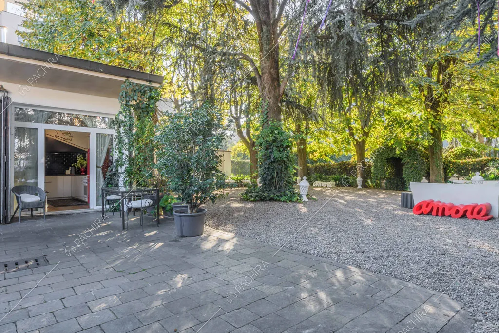 Vista sugli esterni bianchi della location e sul giardino con siepi
