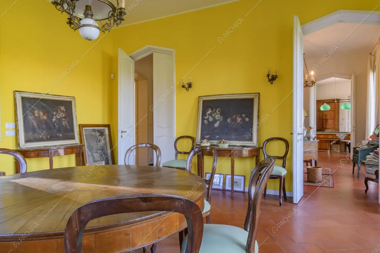 Dalla sala da pranzo dalle pareti gialle scorcio sulla stanza con biliardo