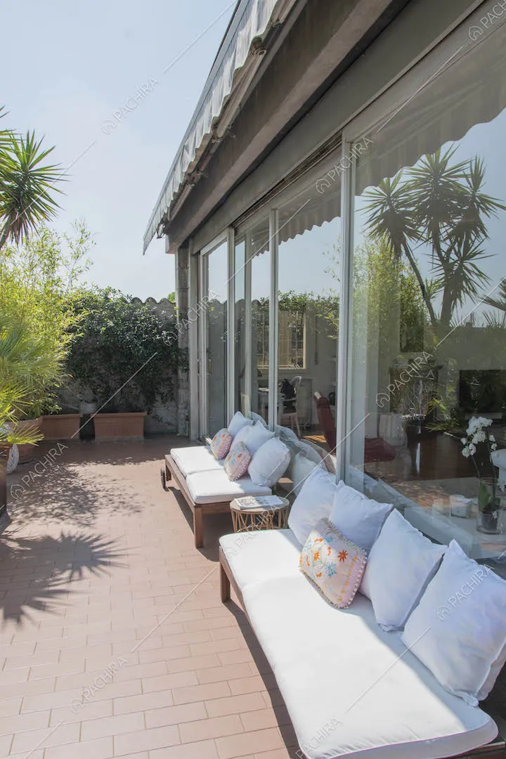 Divani bianchi sulla terrazza e vista sulle vetrate della zona living