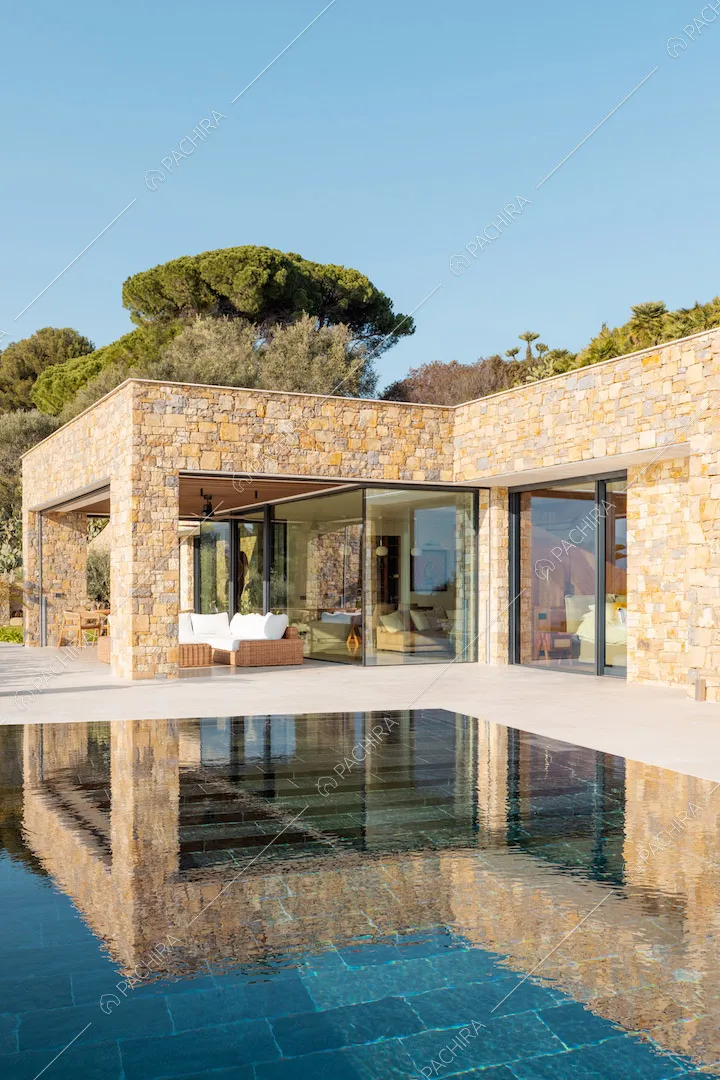 Dalla piscina a sfioro vista sugli esterni in pietra della location e sulla veranda