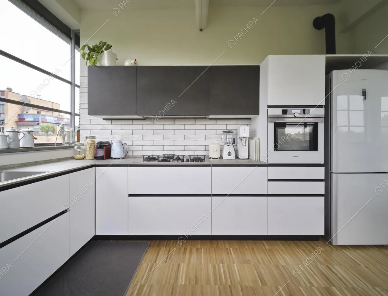 Cucina con parete verde, paraschizzi in mattoni bianchi a vista e pavimento in parquet