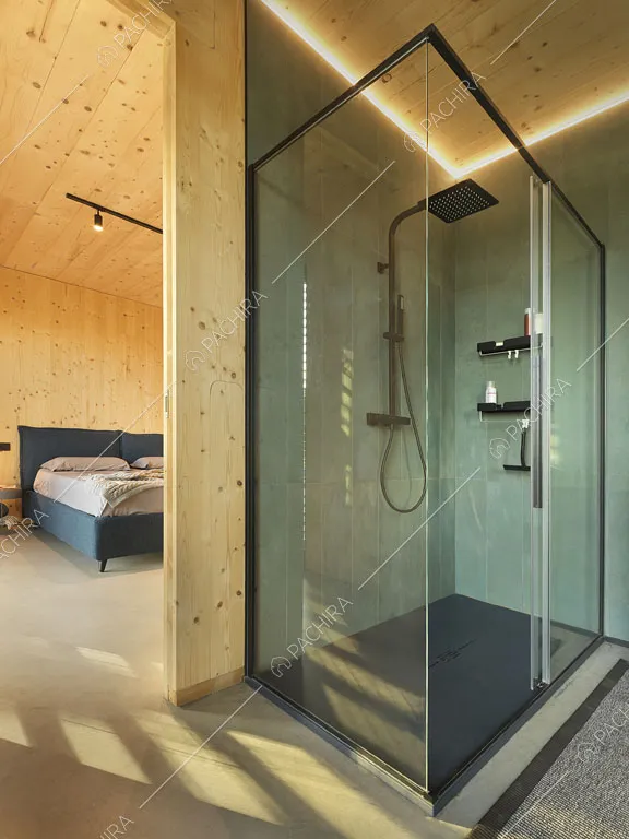 Ampio box doccia con pareti in vetro nel bagno privato della camera da letto matrimoniale