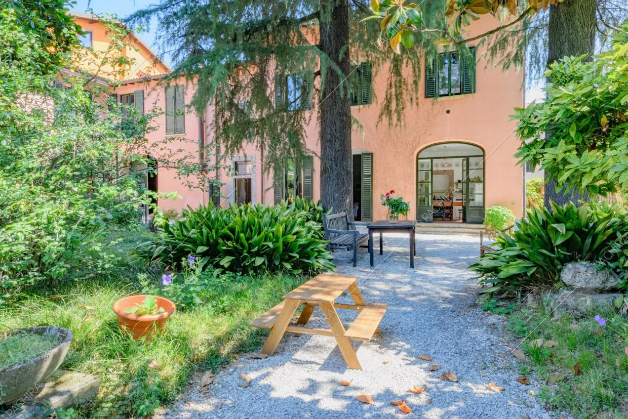Pavimentazione in ciottoli, panchine e vista sugli esterni rosa