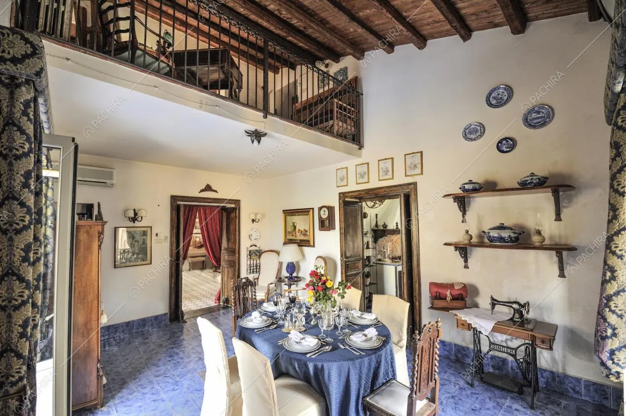 Tavolo da pranzo ovale con sedie rivestite in stoffa e antica macchina da cucire