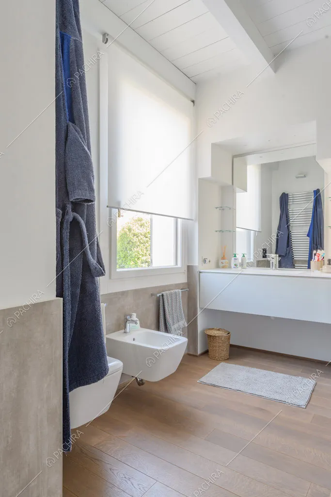 Grande bagno con soffitto in travi bianche in legno e pavimento in parquet