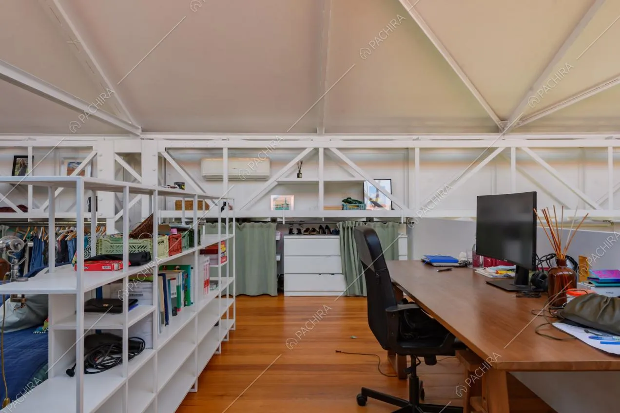 Pavimento in parquet sul soppalco con scrivania e travi in metallo bianco a vista 