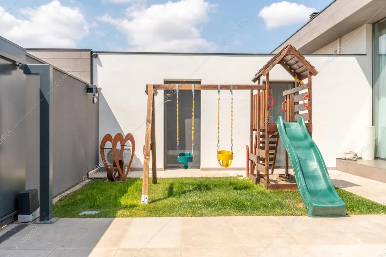 Zona giochi con scivolo e altalene nel giardino della villa