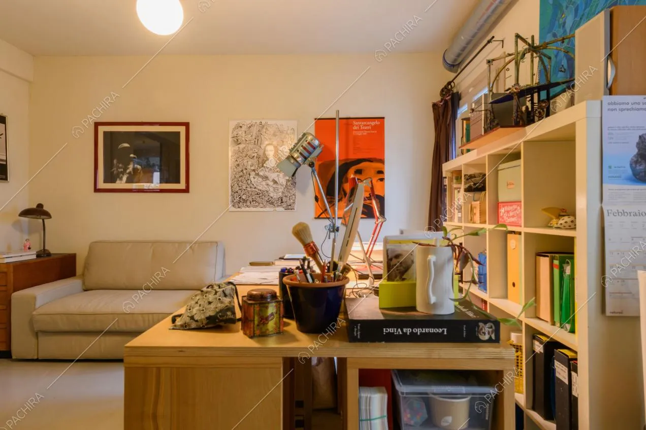 Scrivania nel luminoso studio con divanetto e pavimento in resina