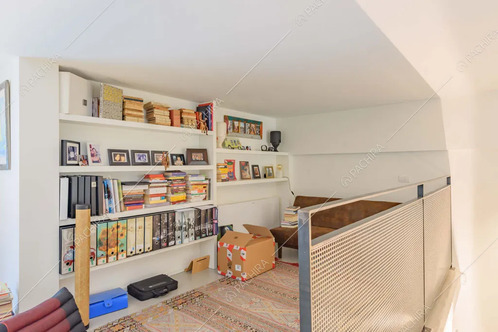 Soppalco con libreria, pareti bianche e balaustra in metallo