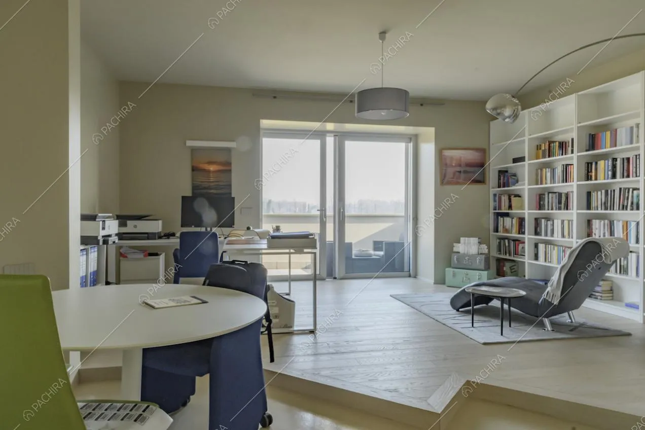 Studio con scrivania, tavolo bianco, poltrona e lampada di design