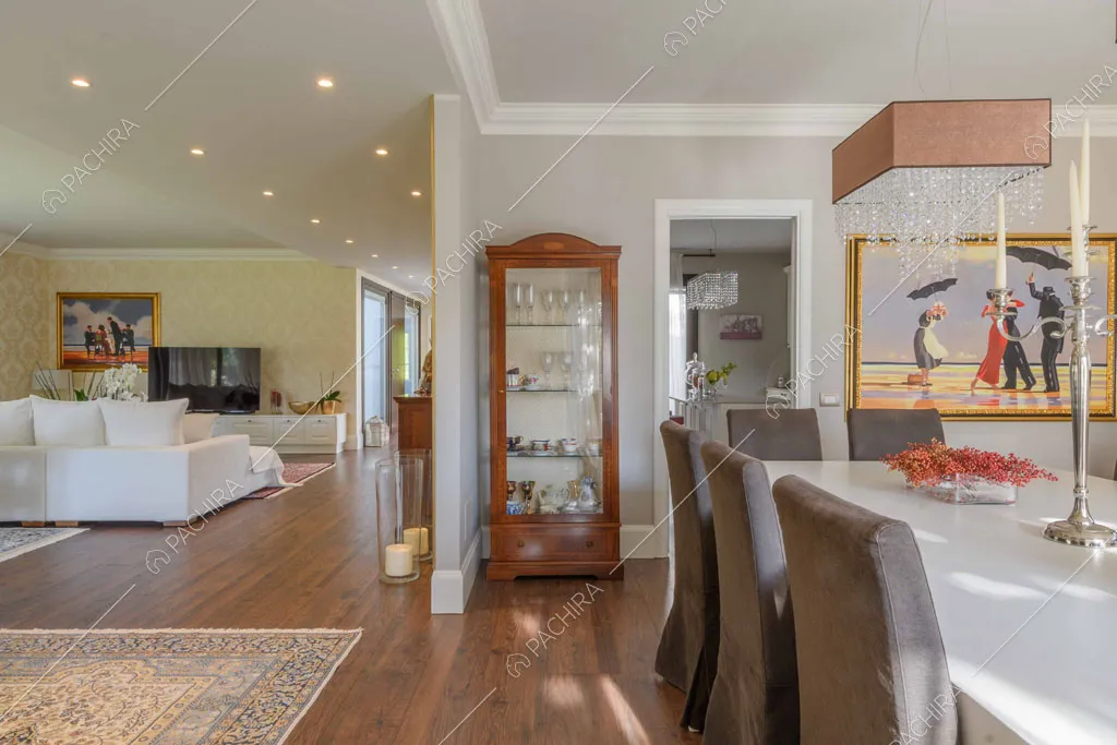 Grande sala con carta da parati, pavimento in parquet e tavolo da pranzo bianco