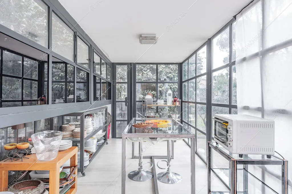 Pareti vetrate in stile industriale nella cucina dell'appartamento Catalpa, location in stile moderno a Roma