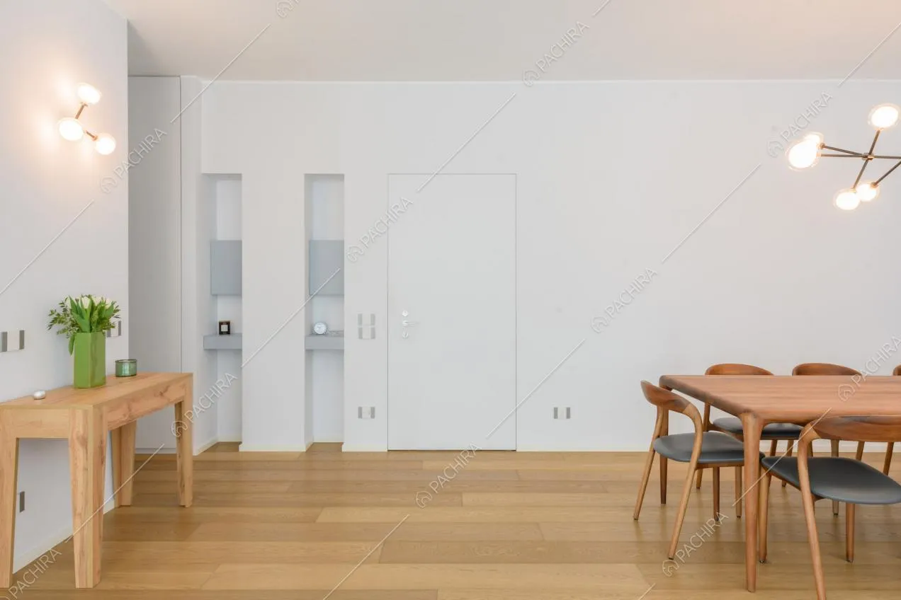 Pavimento in parquet, pareti bianche e tavolo da pranzo nella luminosa sala