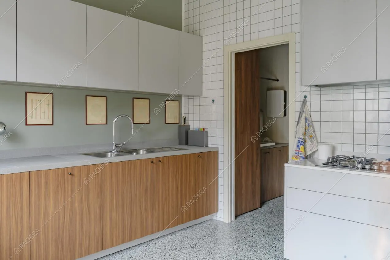 Cucina a muro con pareti verde e bianca a piastrelle, fornelli a gas e pavimento in marmo