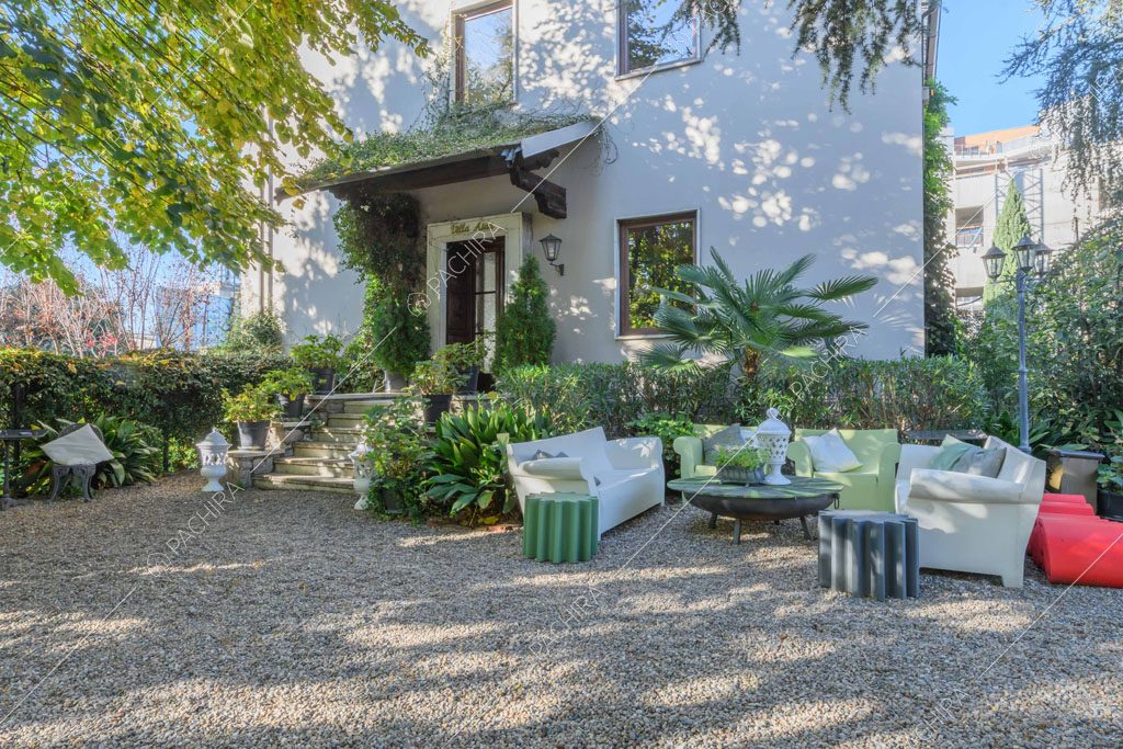 Grande giardino con salotto da esterni bianco e verde