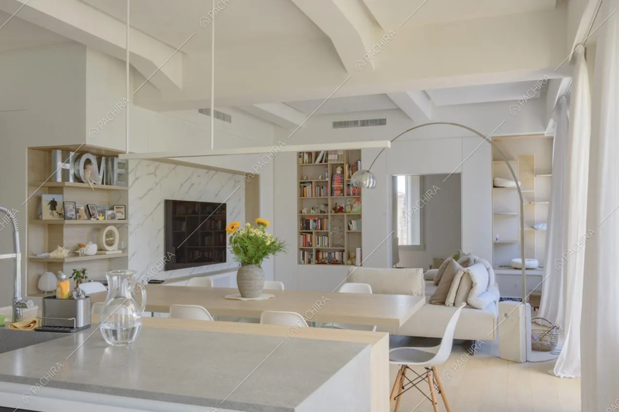 Soggiorno con mensole, televisore e libreria visto dalla cucina 