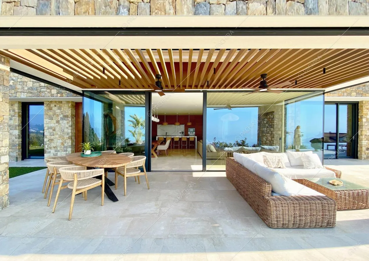 Tavolo da pranzo e divano angolare in vimini nella veranda sulla terrazza