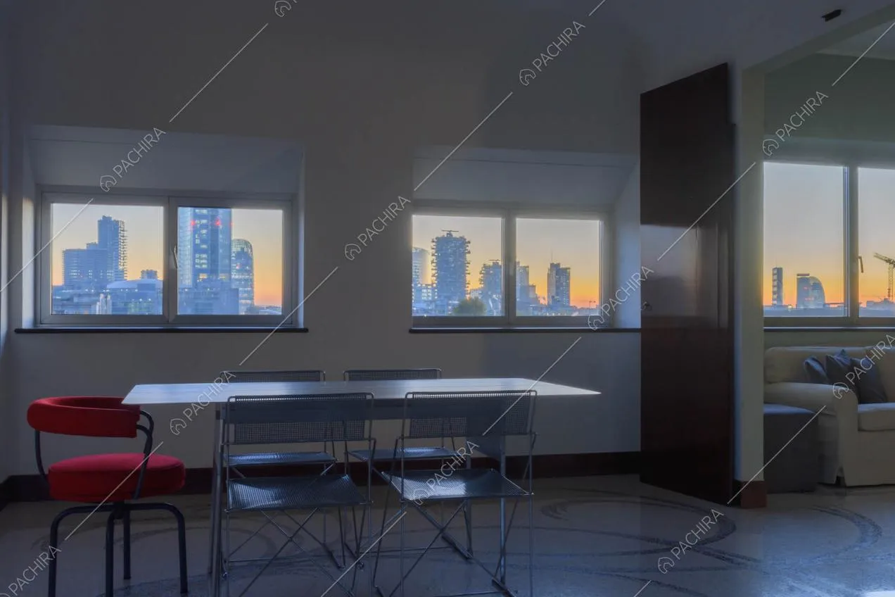 Sala con pavimento in marmo, tavolo in metallo con sedie e vista sullo skyline