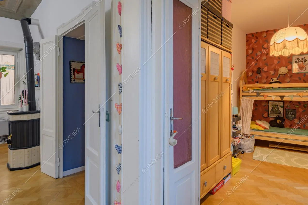 Dalla zona living vista sulla camera da letto dei bambini con carta da parati con fiori