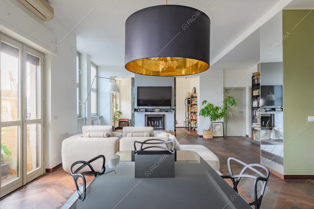 Luminosa zona living con vetrate e pavimento in parquet a spina di pesce