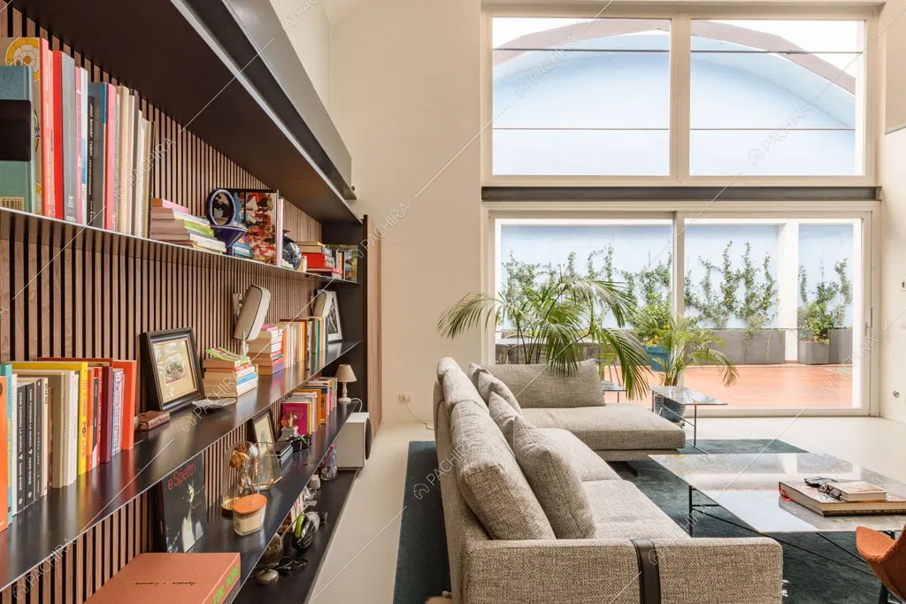 Luminosa zona living con libreria del loft Genepi, location in stile contemporaneo a Milano