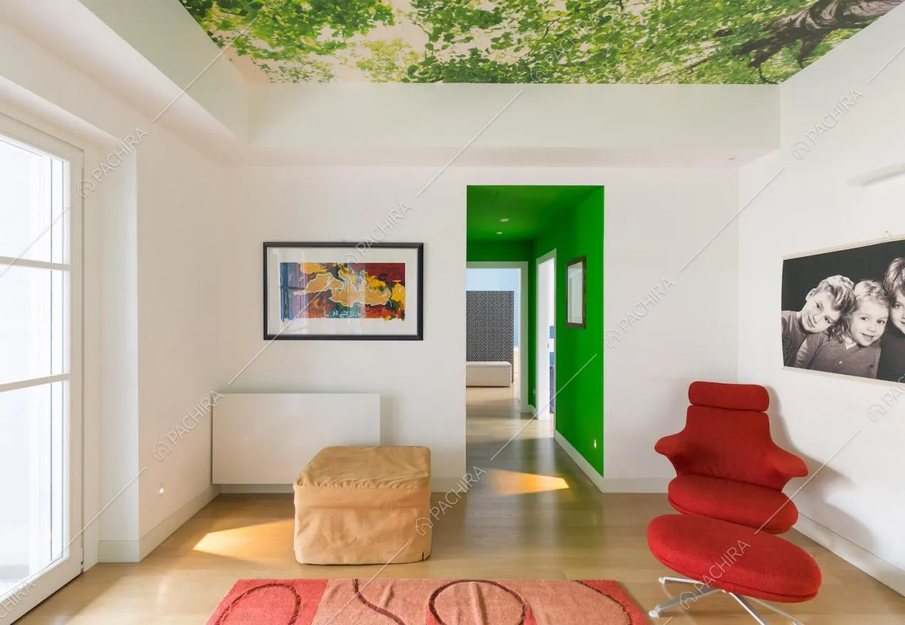 Salotto con poltrona rossa di design e carta da parati sul soffitto