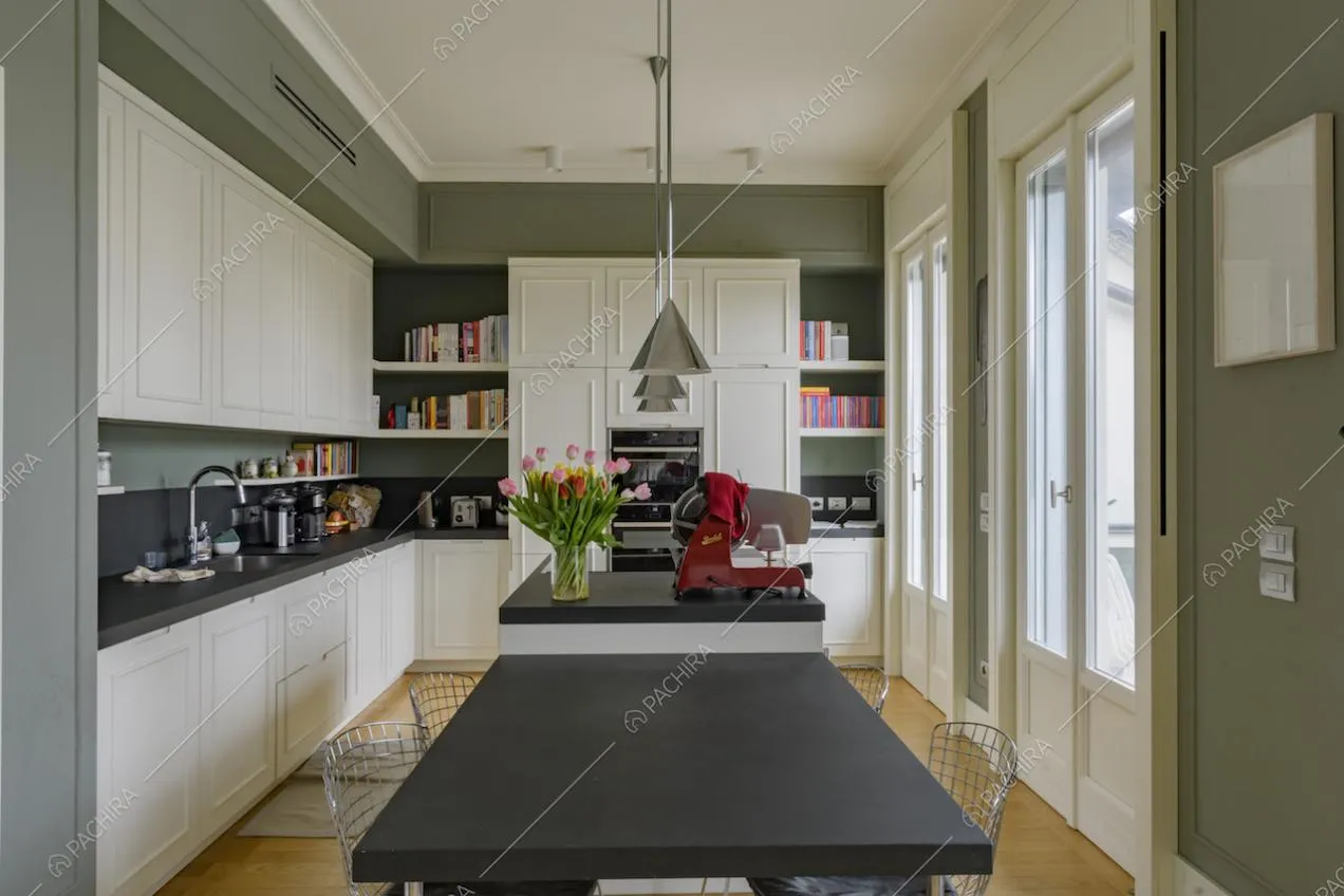 Tavolo nero con sedie in metallo nella cucina con isola e pavimento in parquet