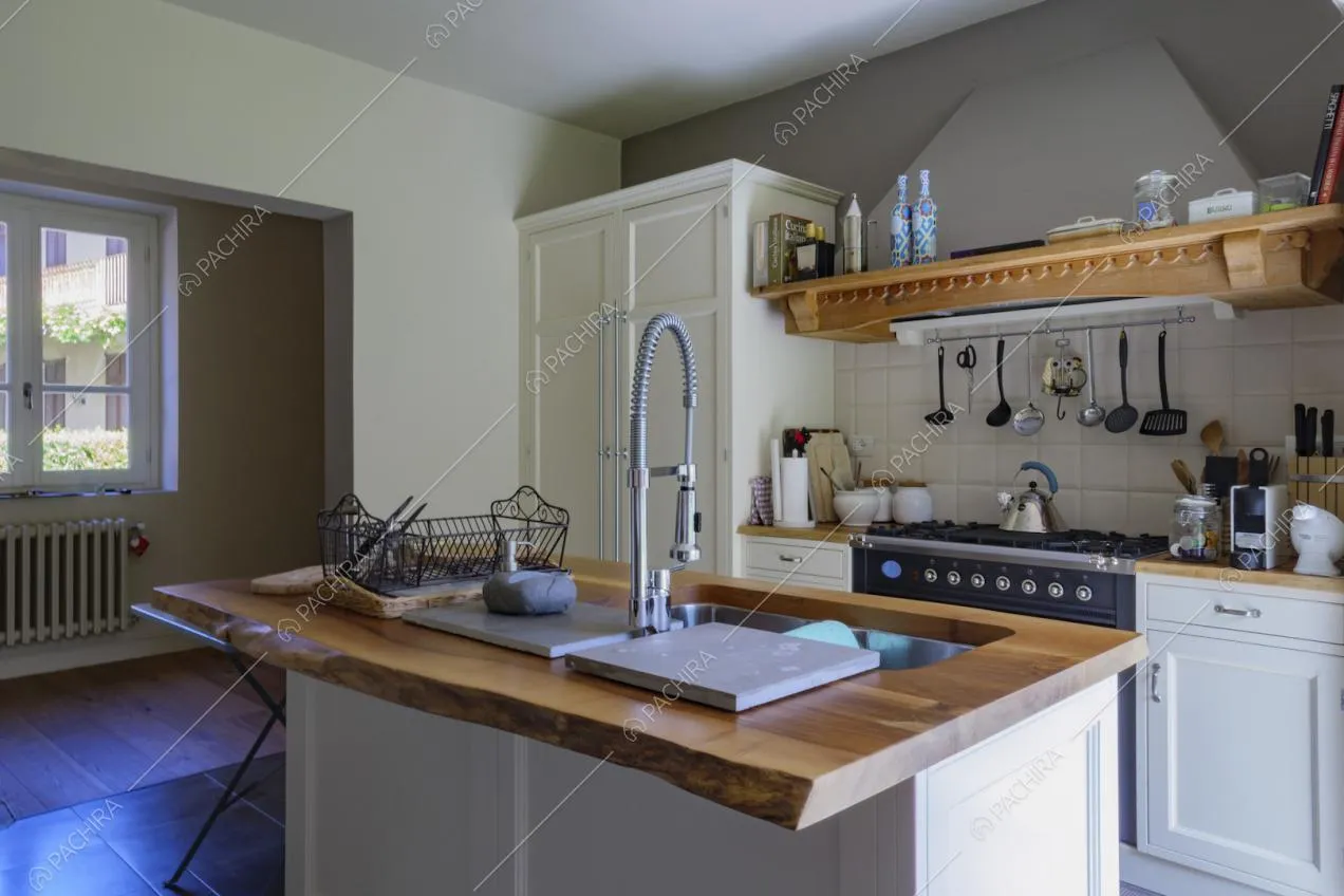 Isola con piano da lavoro in legno nella cucina con fornelli a gas
