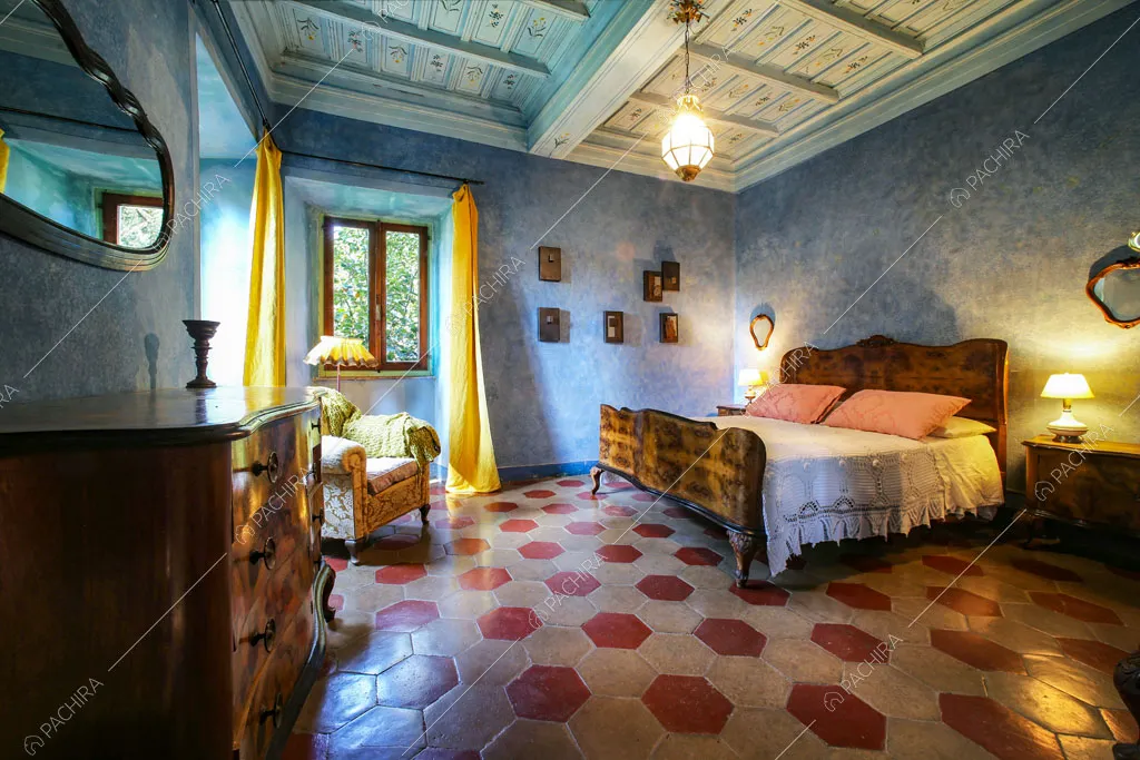 Grande camera da letto matrimoniale con pareti azzurre e soffitto a cassetoni