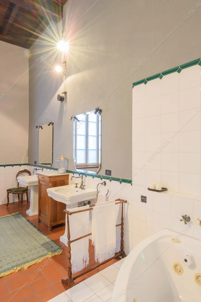 Vasca con idromassaggio nel grande bagno con pareti grigie e in piastrelle bianche