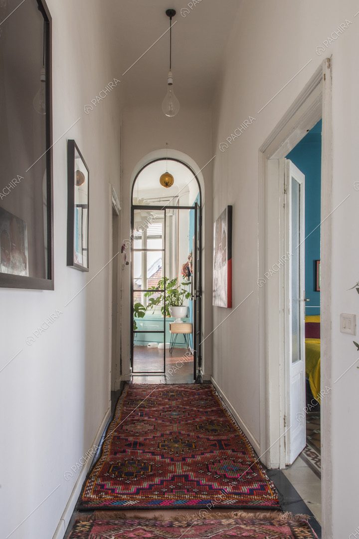 Corridoio con tappeti orientali e porta a vetri ad arco