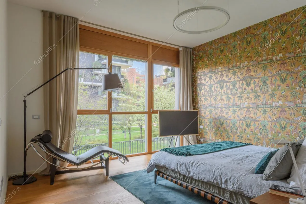 Pavimento in parquet nella camera da letto con chaise longue di design e vetrate