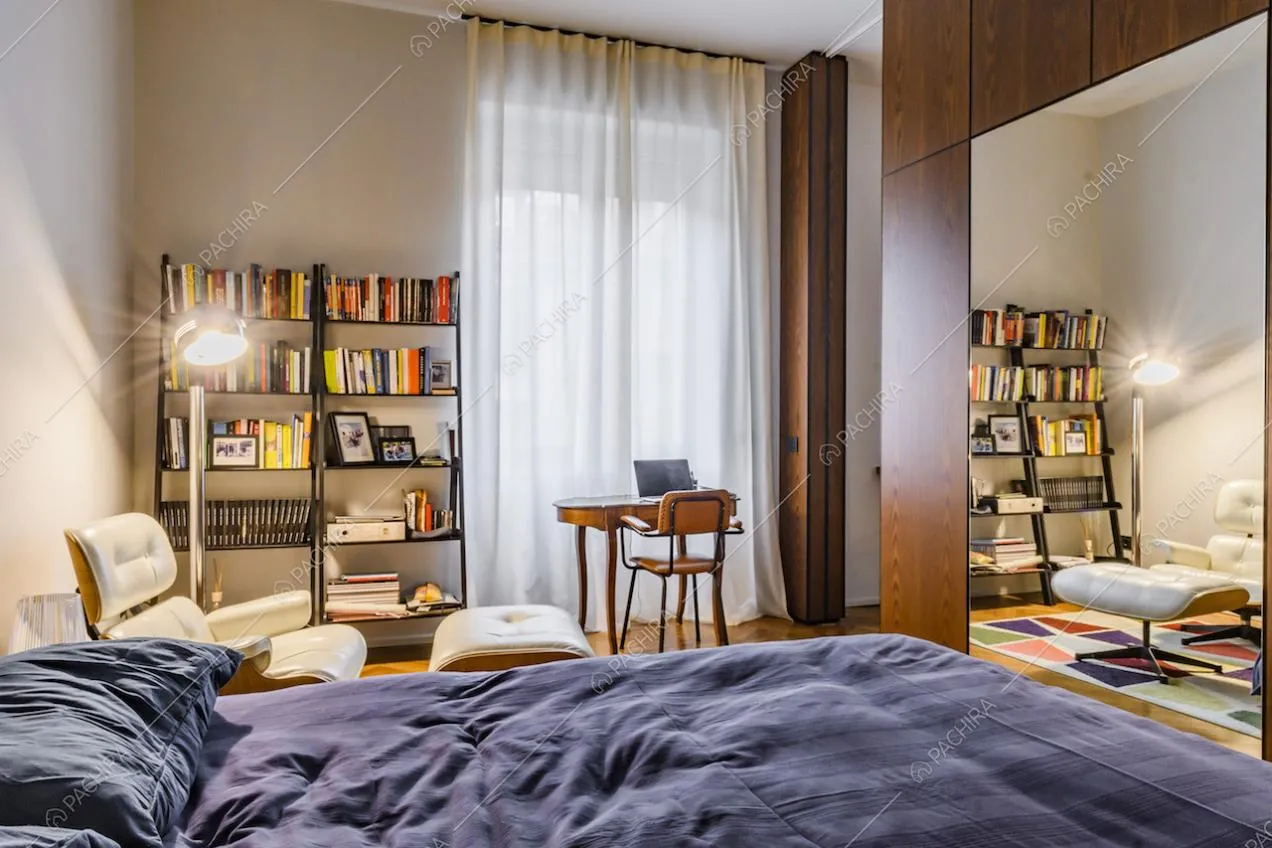 Camera da letto matrimoniale con specchio e poltrona bianca di design