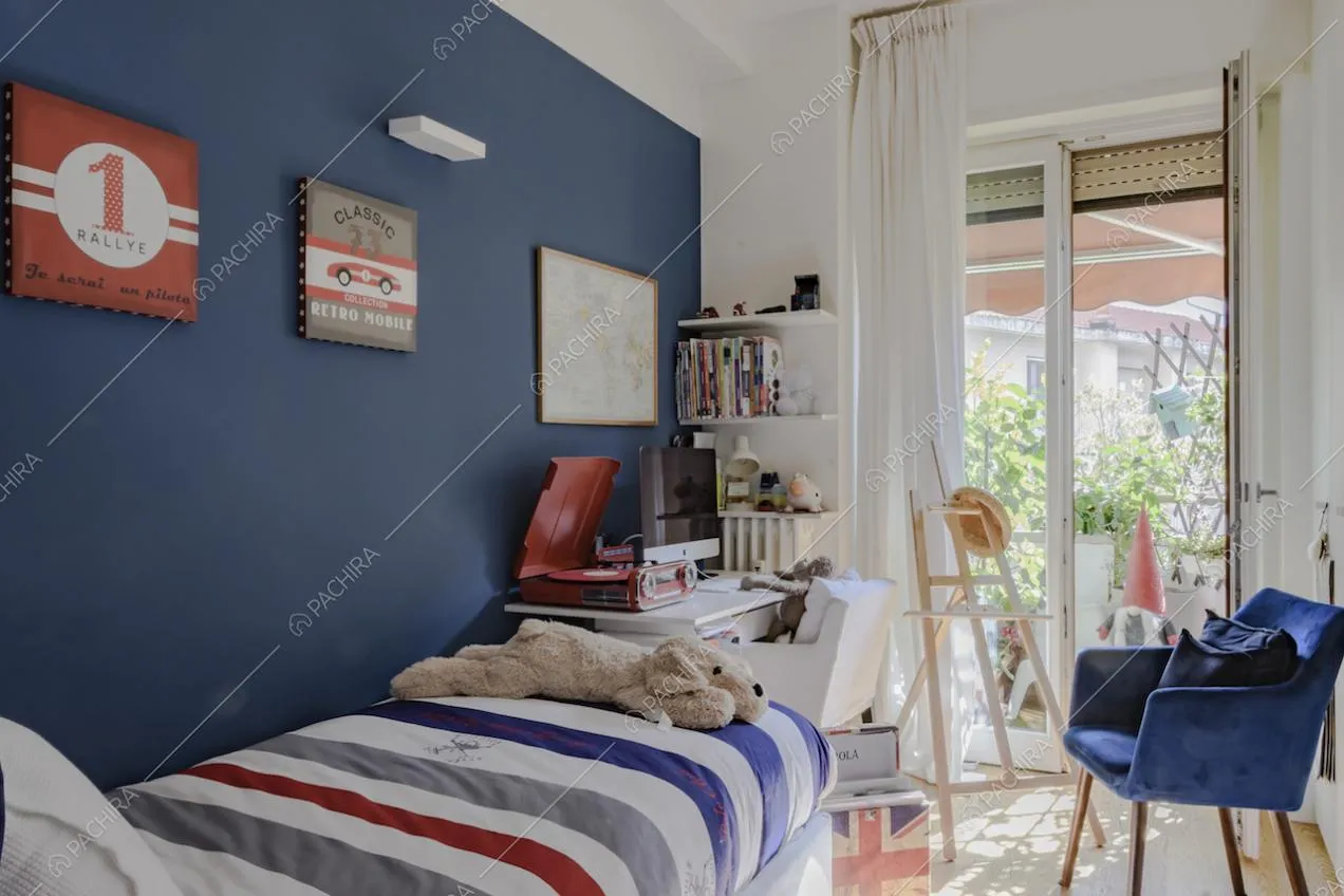 Poltrona in velluto blu, scrivania e letto singolo