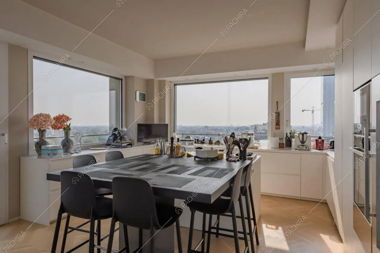 Vetrate con vista sullo skyline nella cucina a isola con tavolo accostato