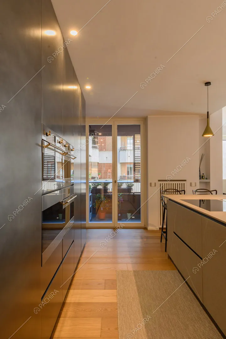 Pavimento in parquet nella cucina con penisola grigia con fornelli a induzione