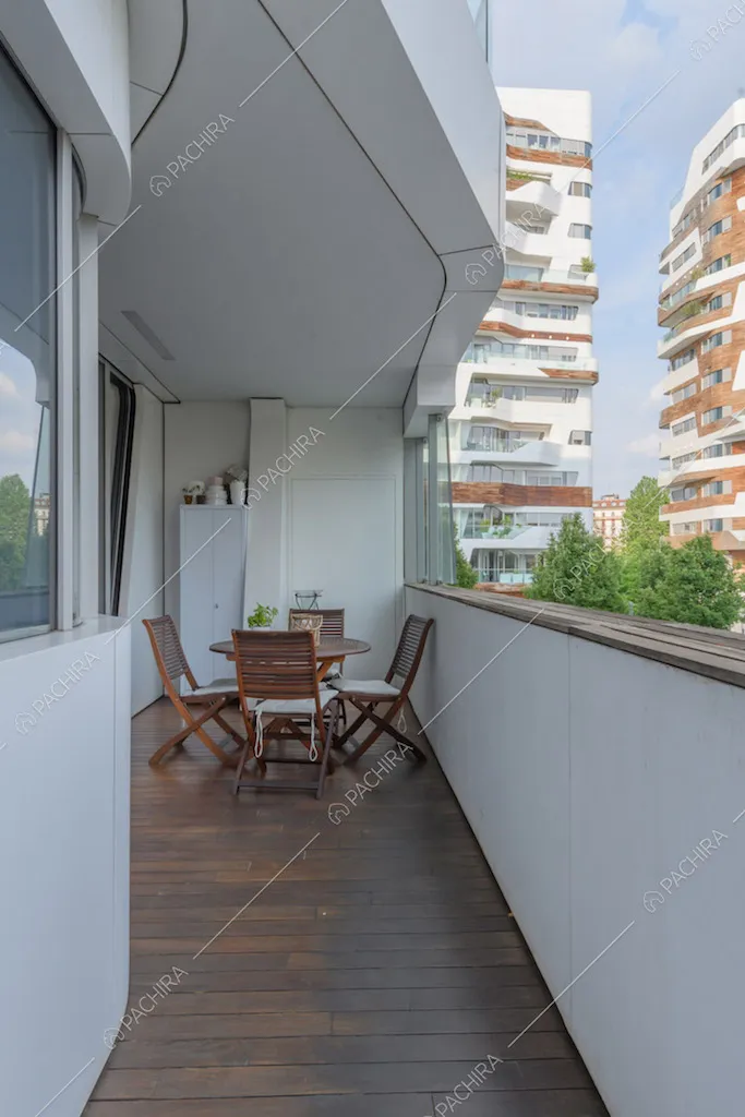 Lunga terrazza con pavimentazione in parquet da esterni e vista sul parco