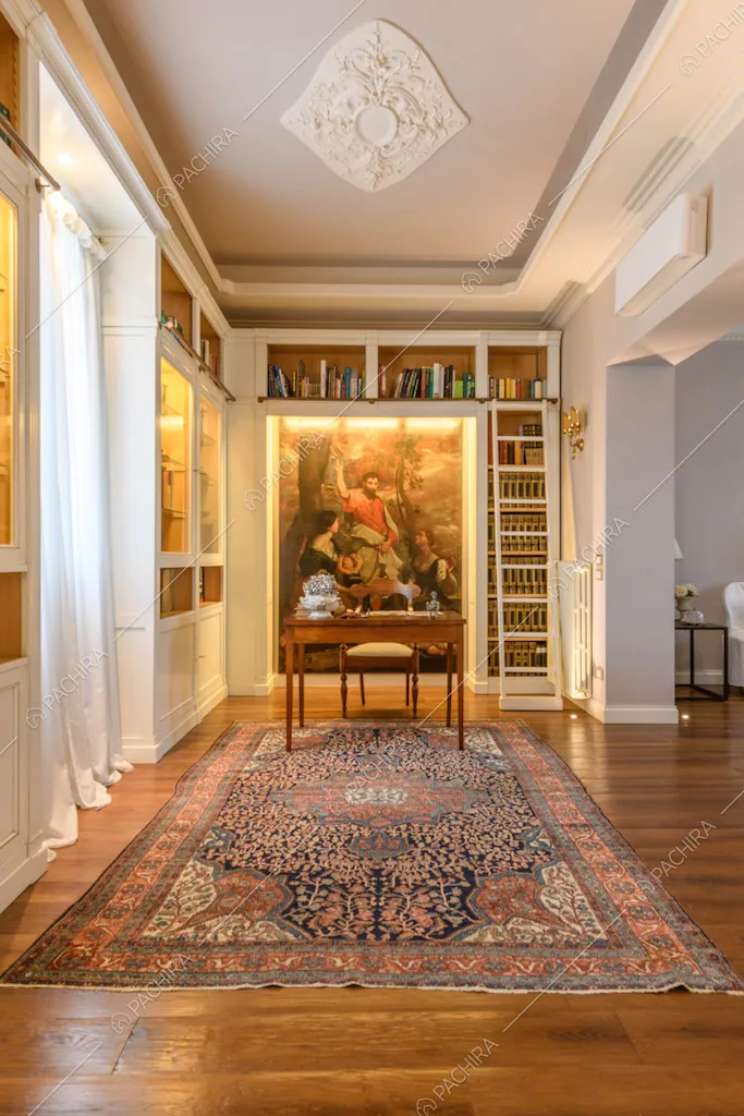 Studio con libreria a parete, boiserie sul soffitto e antica scrivania in legno