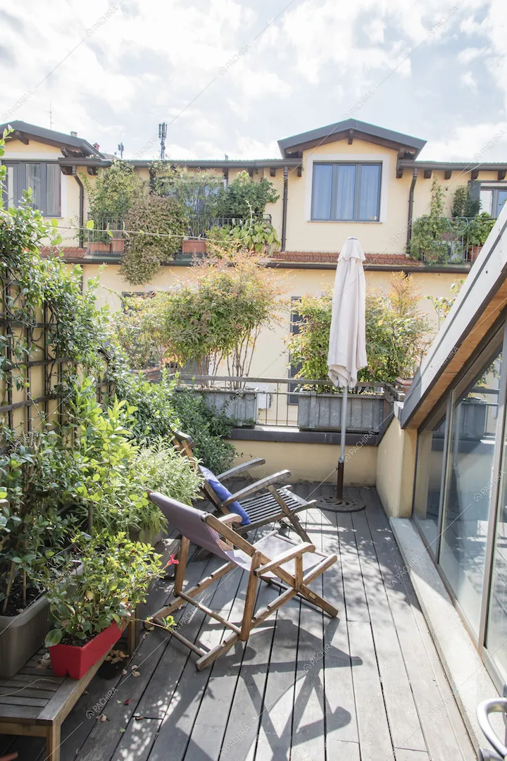 Terrazza con pavimentazione in parquet, piante e sdraio