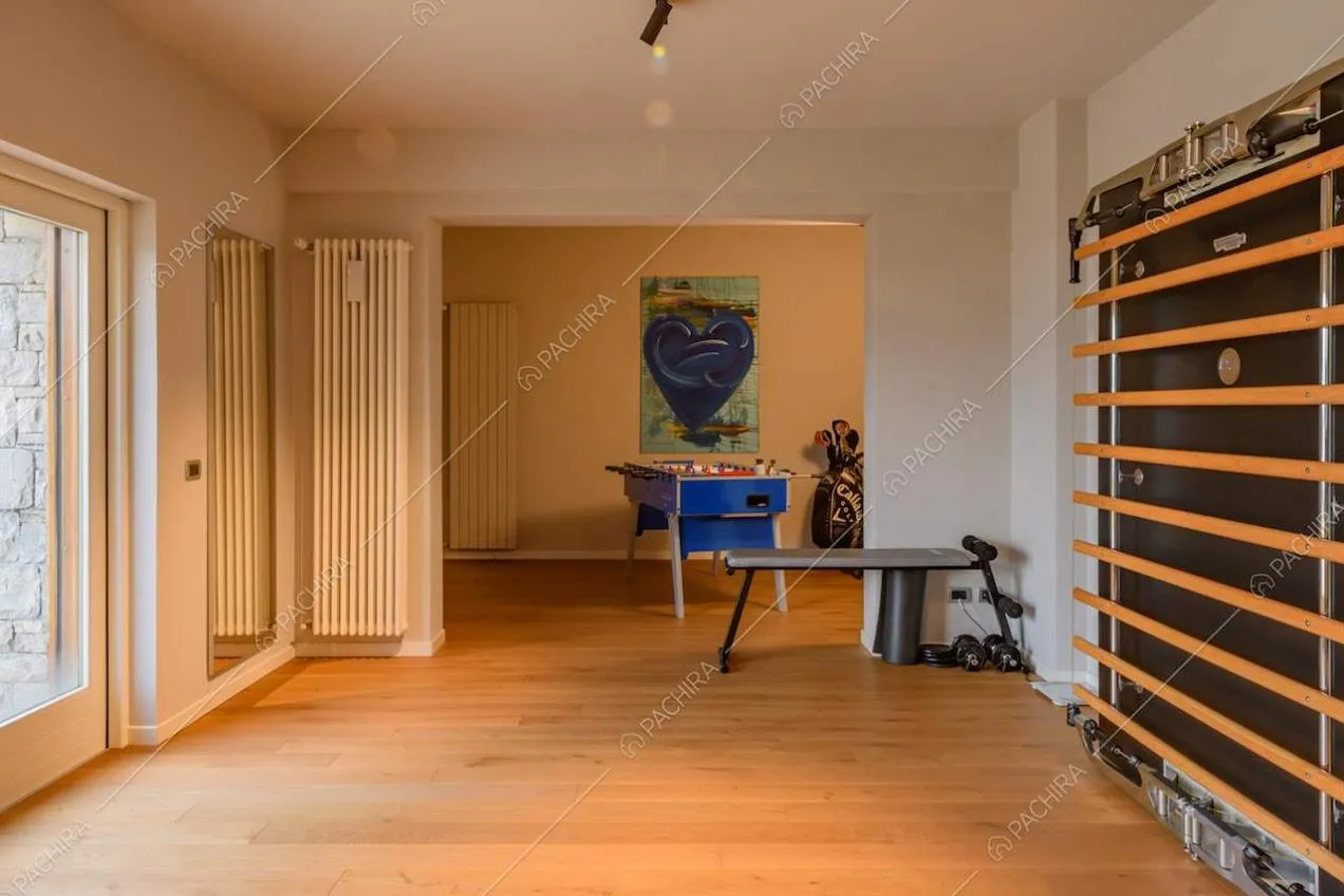 Pavimento in parquet, pareti bianche e vetrata nella palestra