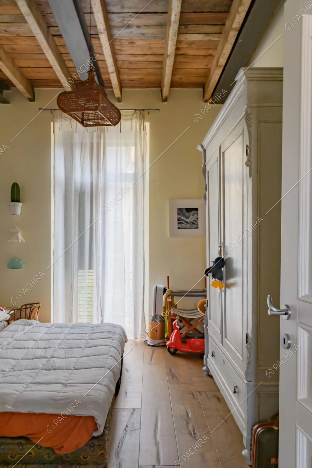 Camera da letto da bambini con pavimento in parquet di rovere e soffitto in travi in legno a vista