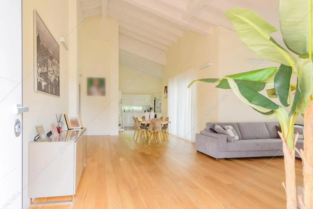 Pavimento in parquet nella luminosa sala con travi bianche a vista sul soffitto