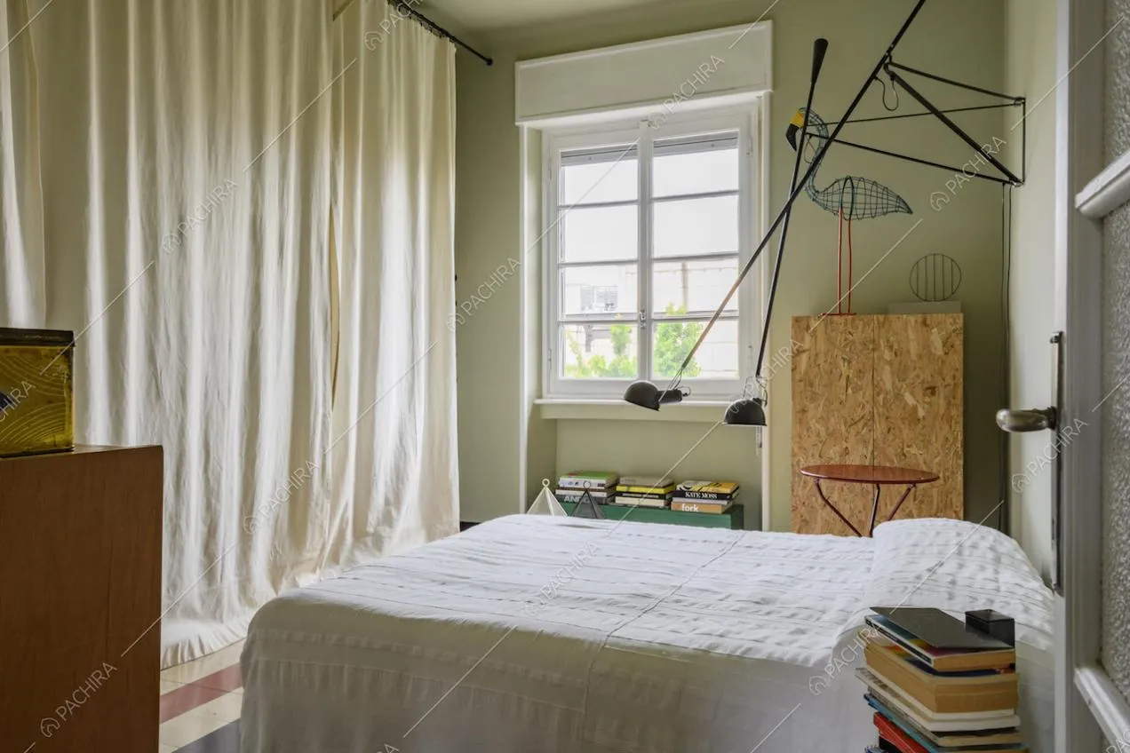 Letto matrimoniale e tendaggio bianco
