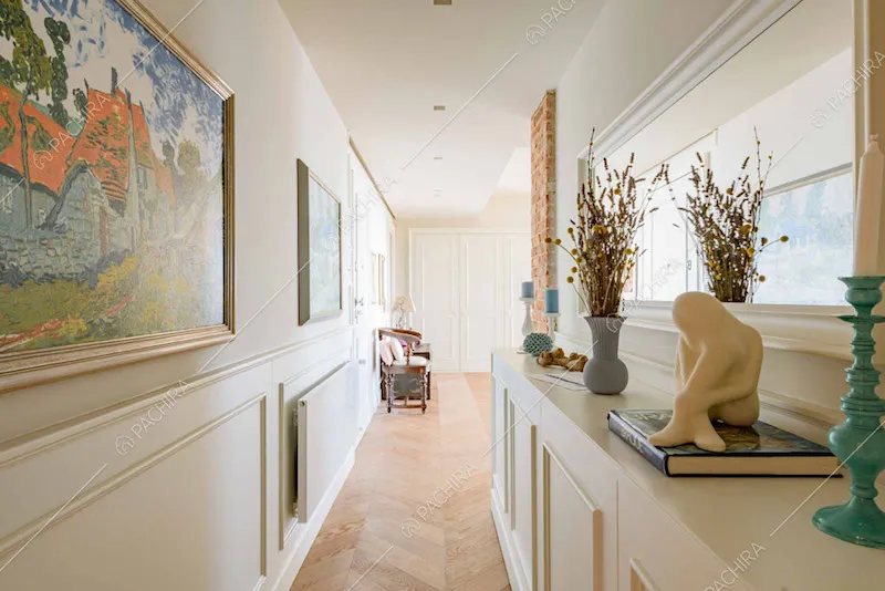 Lungo corridoio con boiserie sulle pareti e pavimento in parquet a spina di pesce