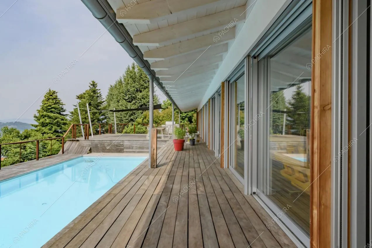 Sulla terrazza con vista panoramica, pavimento in parquet, piscina e porte-finestre scorrevoli