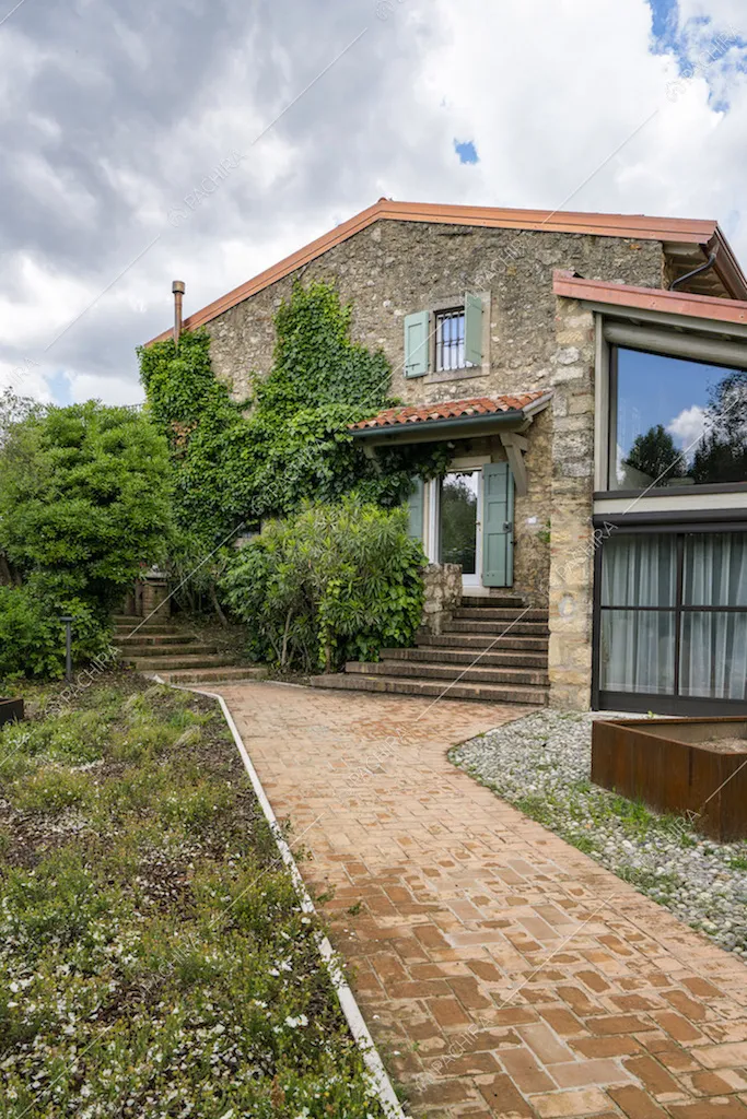 L'esterno della villa con pareti in mattoni e vialetto
